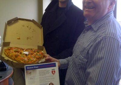 Jordan Ryan from Boston Pizza delivers a complimentary heart shaped pizza to Terry Matchett at Mighty Miramichi